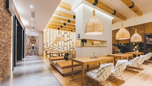 A modern restaurant with wooden tables, white chairs, and hanging wicker lamps. - Atour Hotel Sun YatSen Mausoleum Scenic Spot Nanjing (Nanjing)