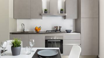 Apartamento luxo, sacada | Cozinha privada | Geladeira grande, fogão, cooktop, talheres/pratos/utensílios de cozinha