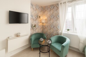 Apartamento, vistas a la ciudad | Zona de estar | Televisión de pantalla plana de 32 pulgadas con canales por cable