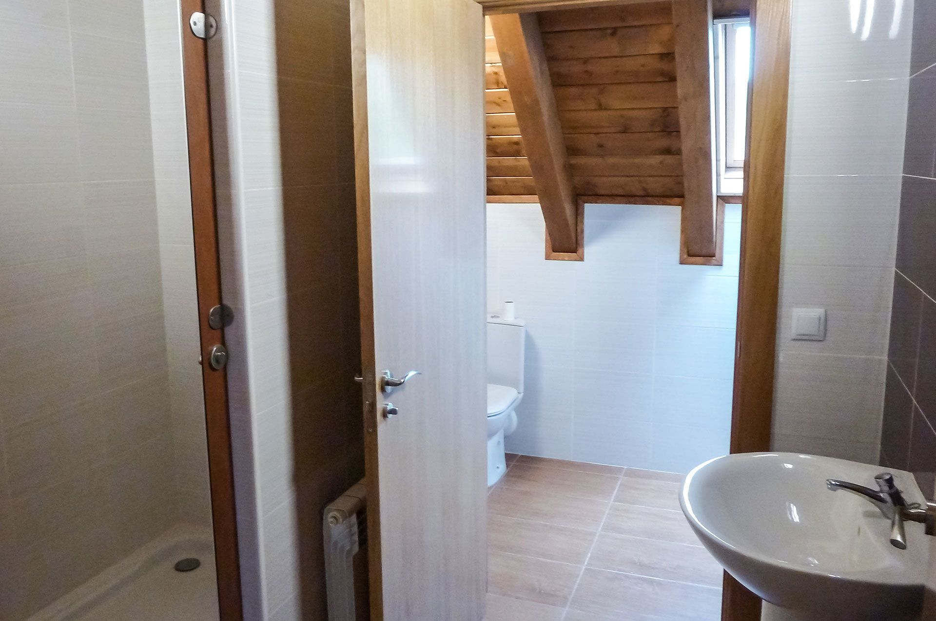 Ein Badezimmer mit Toilette, Waschbecken und Holzboden.