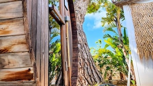 A wooden structure with a large circular window, surrounded by lush greenery and a clear sky. - White Village Boutique, Benalmádena - Self Check-in (Benalmádena)