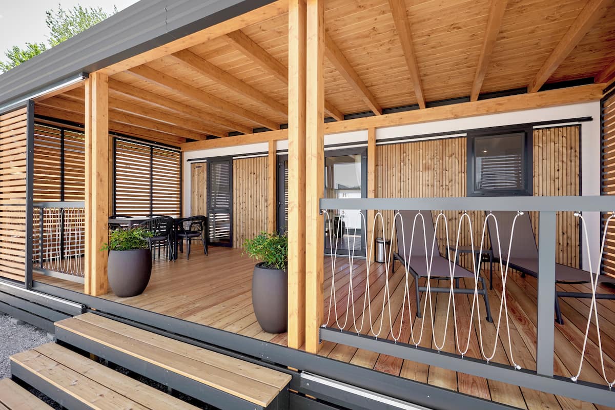 Eine Terrasse aus Holz mit Sitzgelegenheiten und Pflanzen in Töpfen.