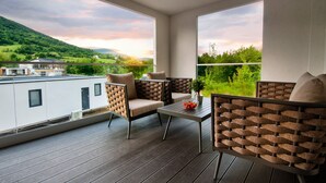 A balcony with two chairs, a table, and a potted plant. - Mobile Homes Camping Plitvice (Plitvicka Jezera)