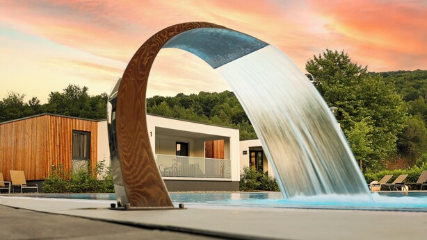 A modern building with a wooden facade and a pool area with lounge chairs. - Mobile Homes Camping Plitvice (Plitvicka Jezera)