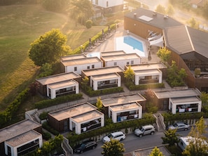 Un complejo residencial moderno con varias casas independientes, una piscina y un aparcamiento.
