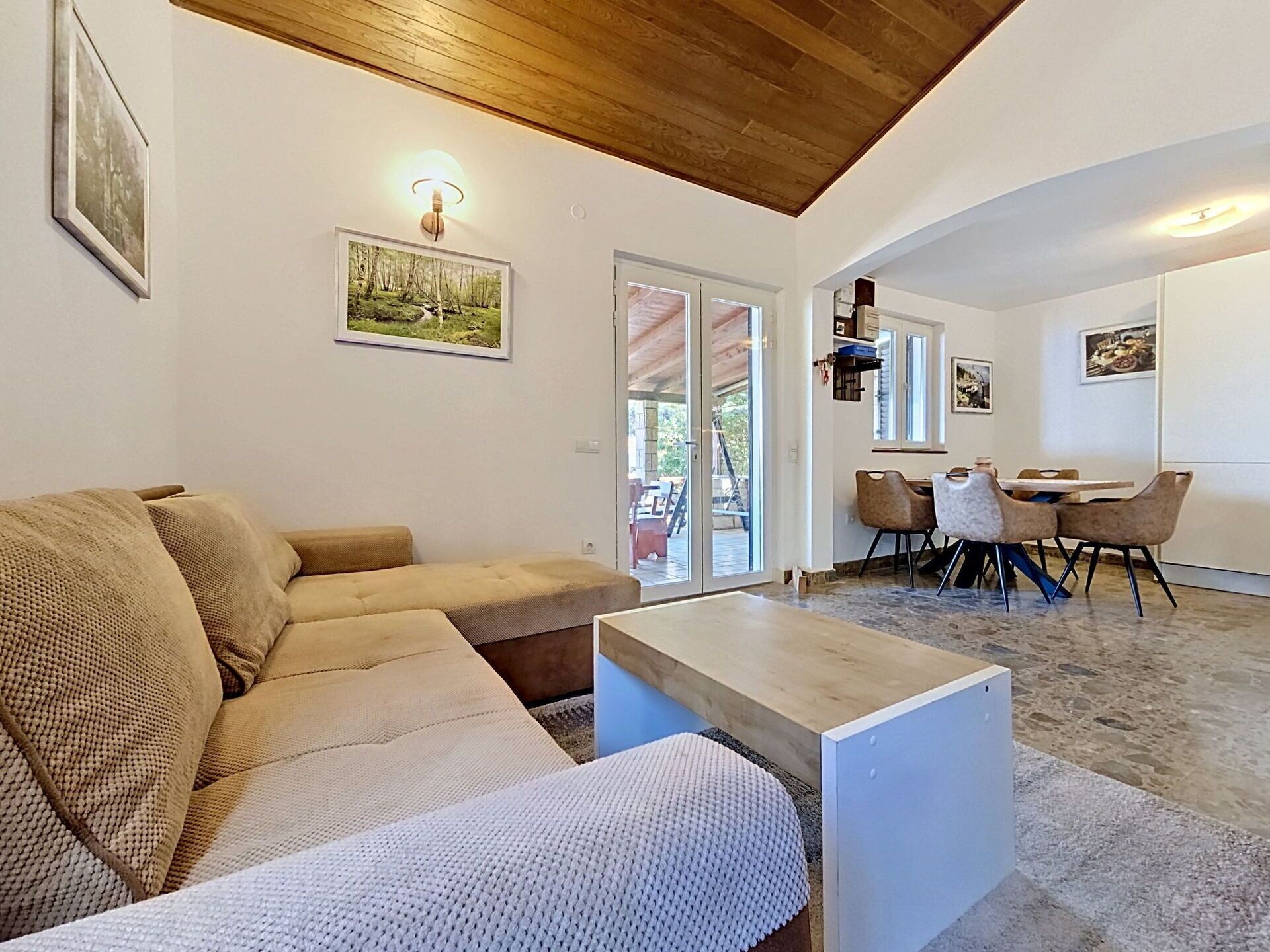 Un salon comprenant un canapé, une table basse et un coin repas avec des chaises et une table.