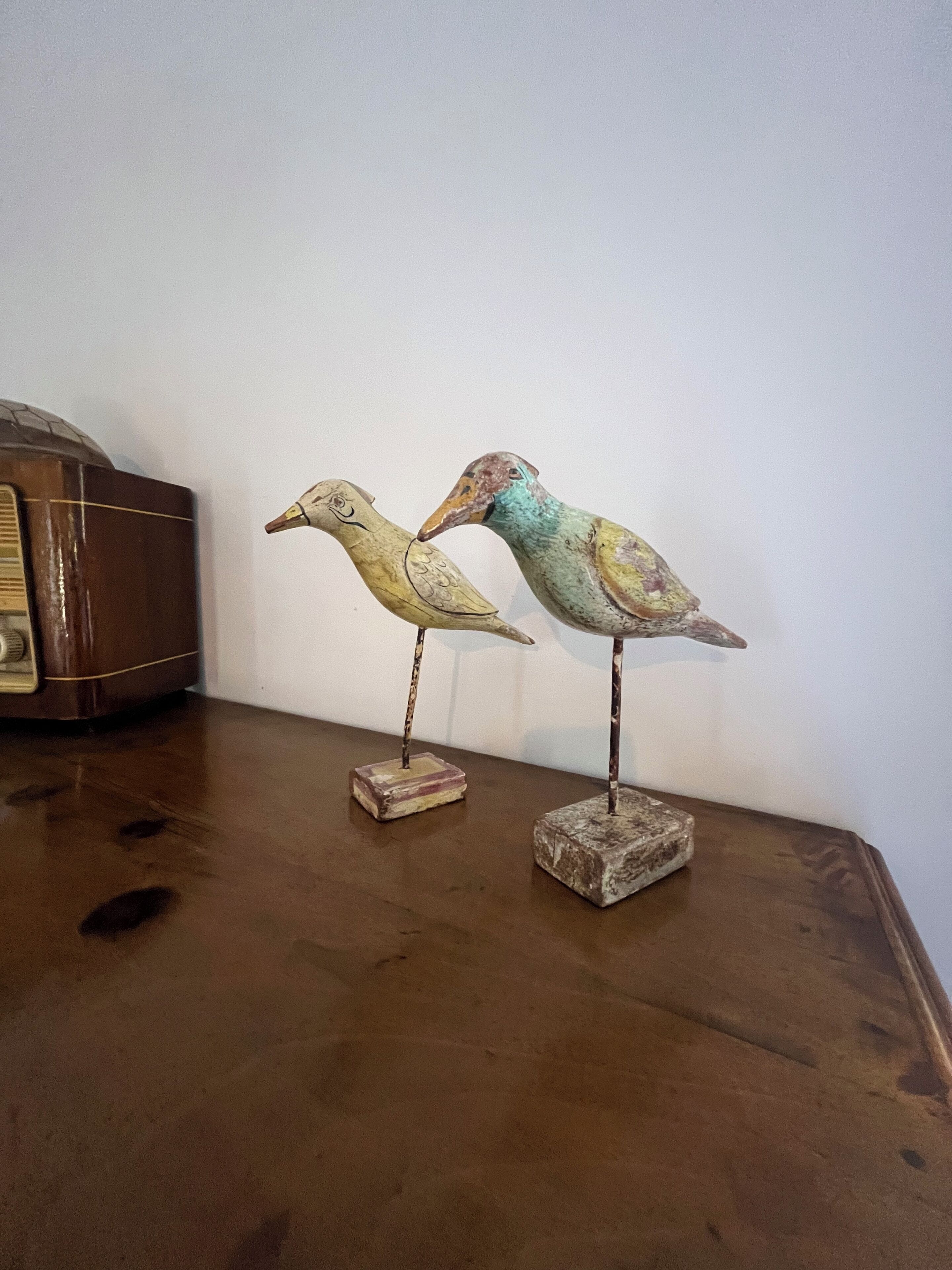 Two bird-shaped sculptures on a wooden table.