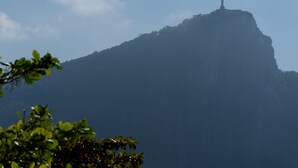 A mountain with a statue on top, surrounded by greenery. - Omar do Rio - VP303 (Rio de Janeiro)