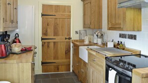 Una cocina con armarios de madera, estufa y lavamanos.