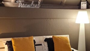 A hotel room with a bed, pillows, a lamp, and a decorative ceiling light. - Odenwald Lounge in the Bergstraße-Odenwald Nature Park (Reichelsheim (Odenwald))