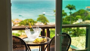 Un balcon avec une table, une bouteille de champagne et un verre d’eau.