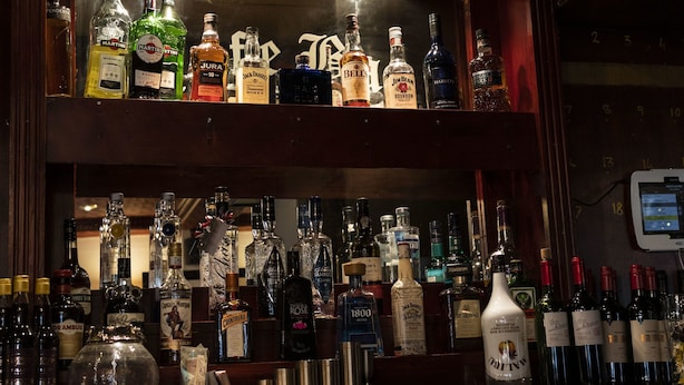 A bar with multiple shelves of liquor bottles.