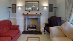 A living room with a fireplace, two sofas, and a large mirror. - Ranscombe House (Brixham)