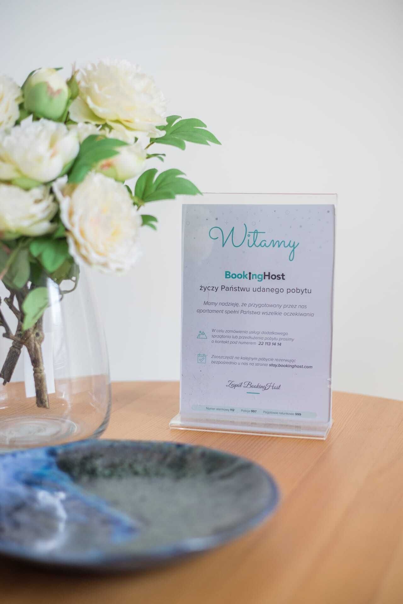 A clear sign with the name 'Witamy' and 'BookingHost' indicating a hotel or booking service.