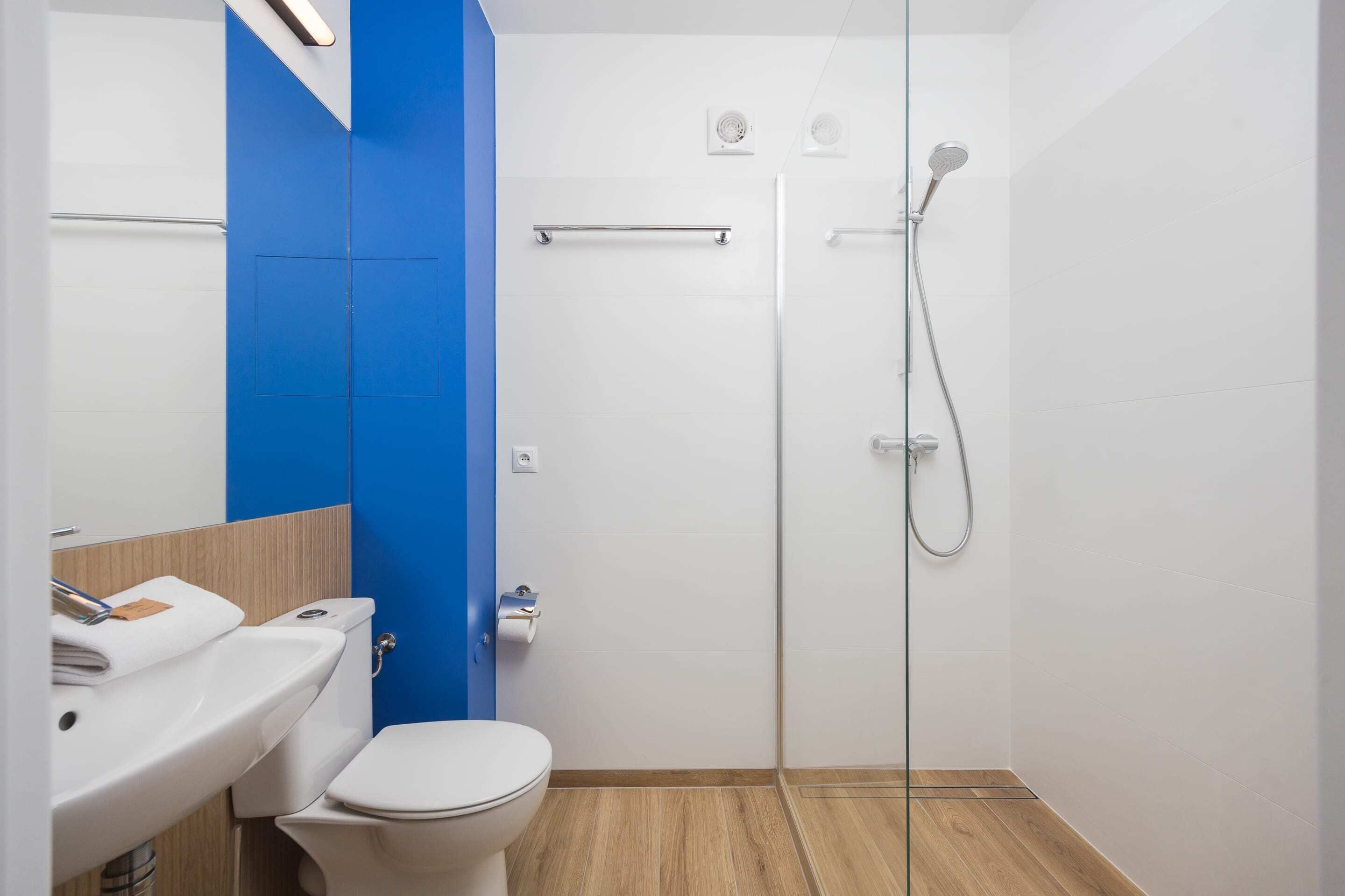 A modern bathroom with a toilet, sink, and shower.