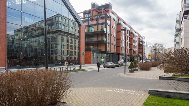 A modern building with large glass windows and a brick facade. - Riverside Comfort Studio (Warsaw)