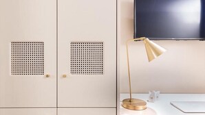 A room with a desk, a lamp, a television, and a wardrobe. - Magville (Milan)