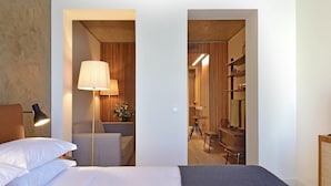 A hotel room with a bed, a desk, a lamp, and a chair. - My Story Apartments Porto - Santa Catarina (Porto)