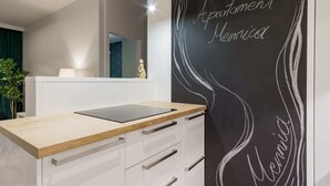 A modern bathroom with a wooden vanity, a black wall with white text, and a mirror above the vanity. - Mennica Residence Chic Apartment (Warsaw)