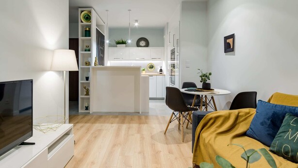 A modern living room with a TV, sofa, and dining area. - Mennica Residence Chic Apartment (Warsaw)