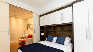 A bedroom with a bed, a wardrobe, a chair, and a ceiling fan. - Omar do Rio - SL109 (Rio de Janeiro)