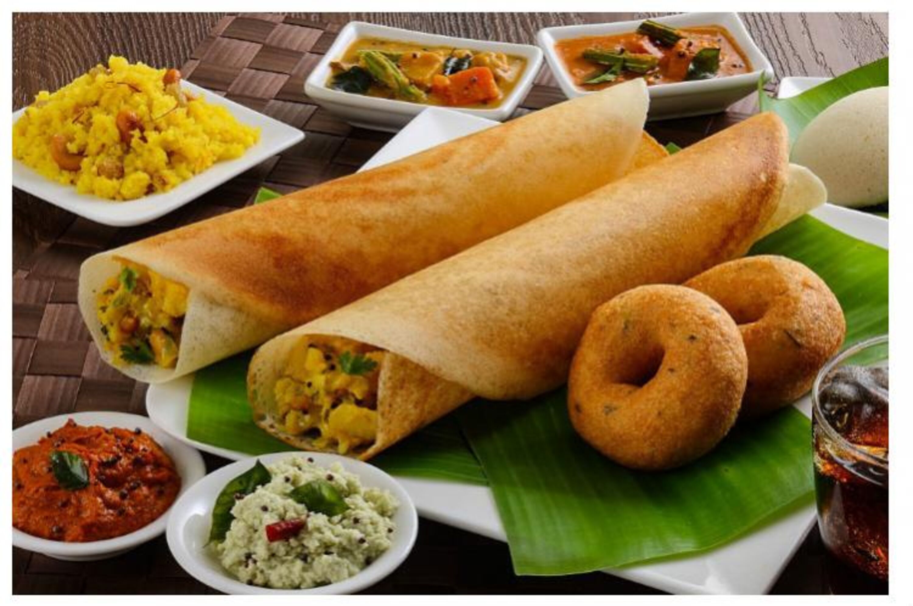 A meal with two wraps, two small round breads, and three small bowls of different dishes.