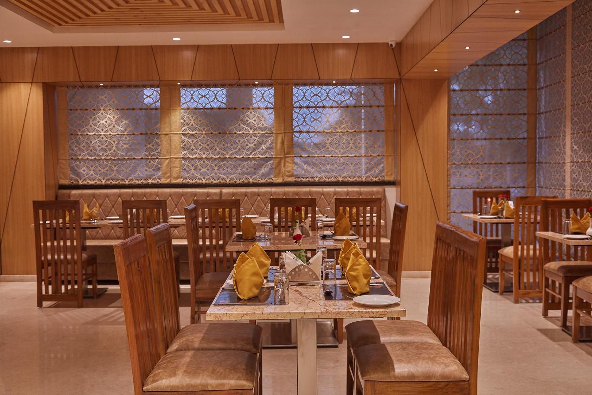 A restaurant with wooden furniture, patterned windows, and a marble table.