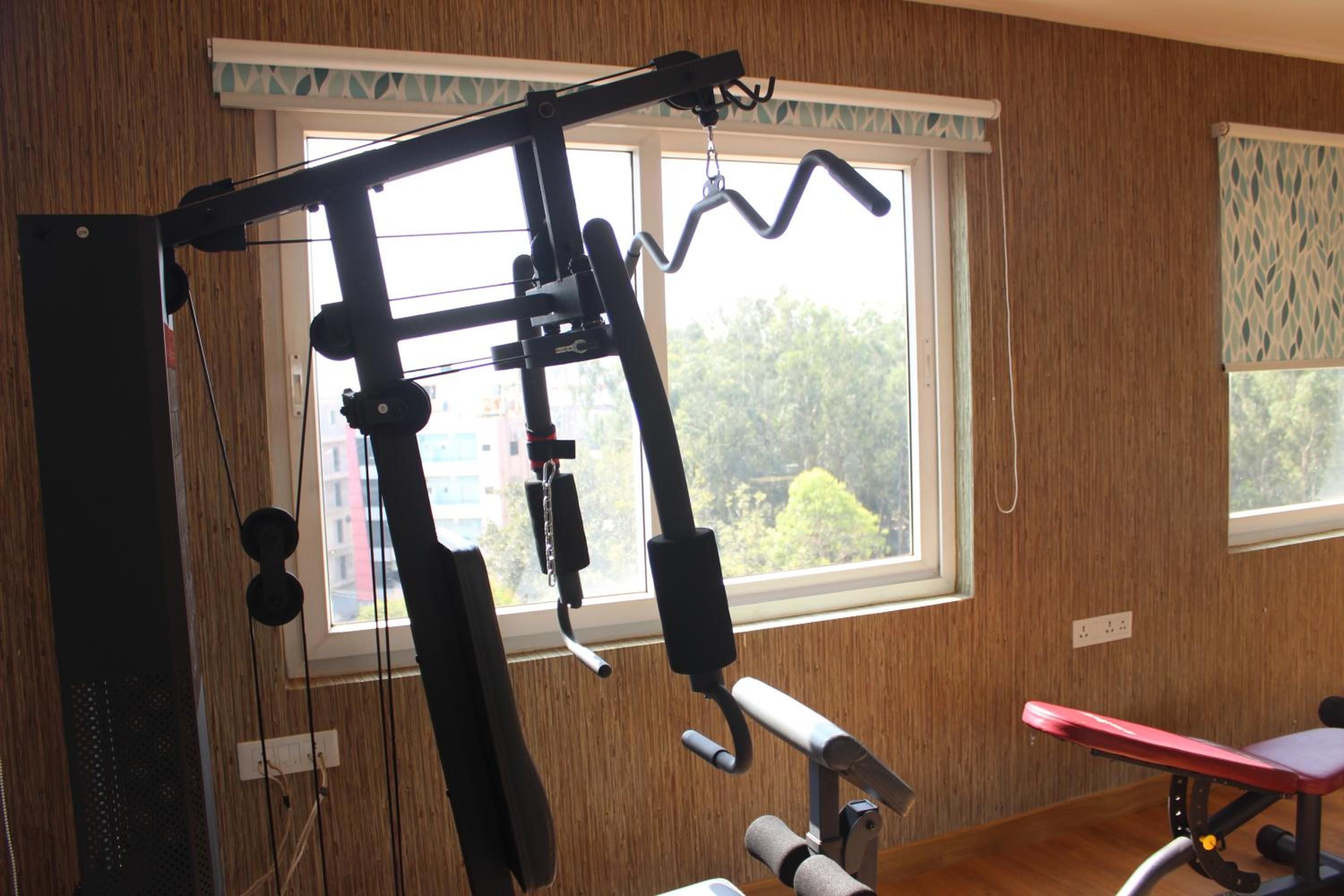 A home gym with a pull-up bar, bench press, and various exercise equipment.
