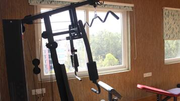 Un gimnasio en casa con barra de dominadas, prensa de banca y diversos equipos de ejercicio.