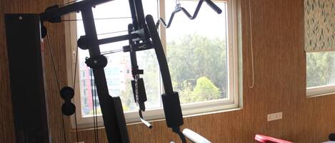 A home gym with a pull-up bar, bench press, and various exercise equipment.