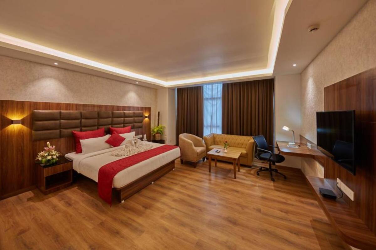 Een moderne hotelkamer met een groot bed, een bureau, een bank en een televisie.