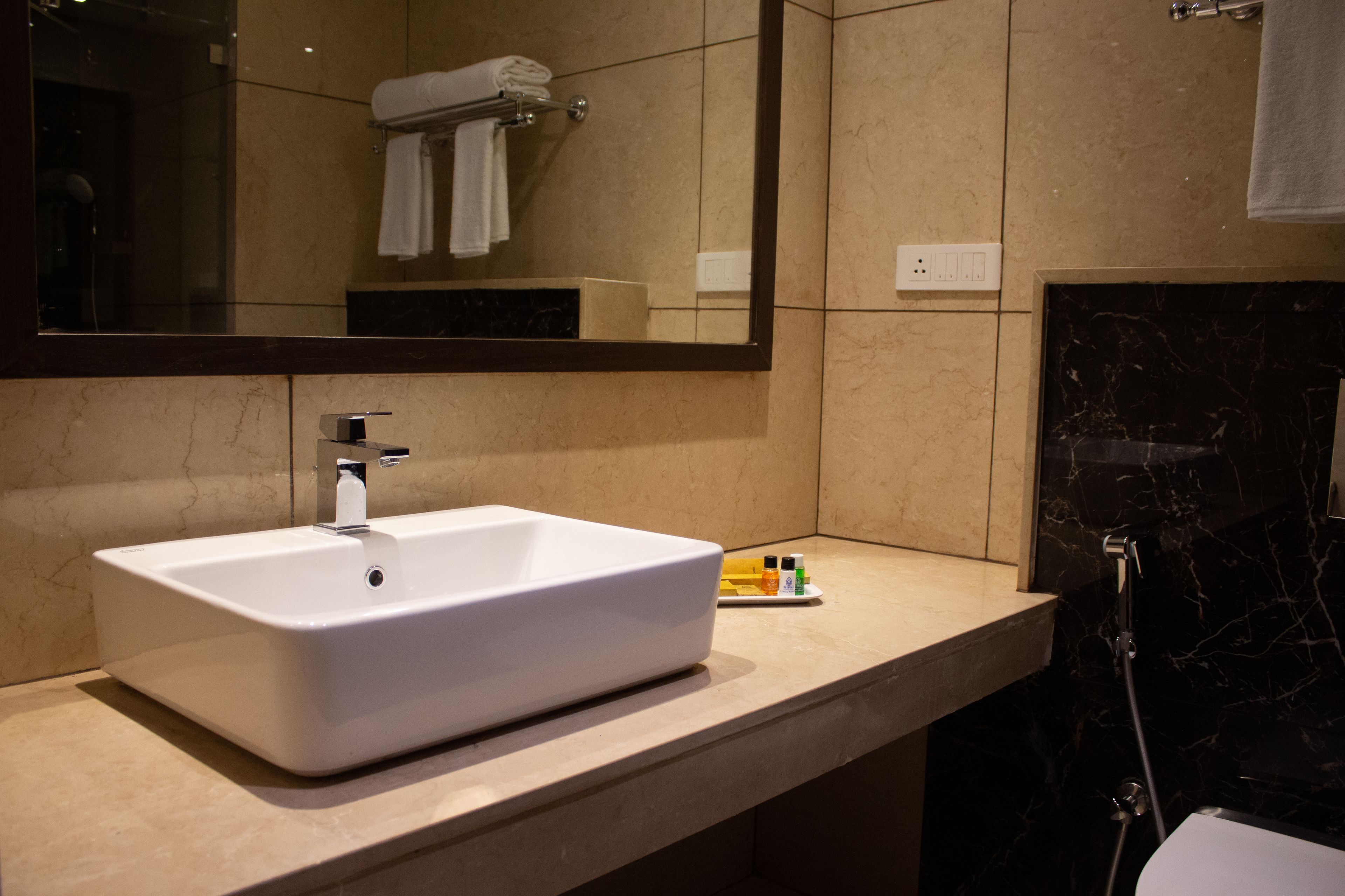 Une salle de bain avec un lavabo blanc, un miroir et un espace douche.