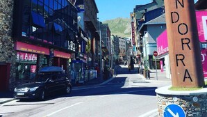 Een straatbeeld met een opvallend bord voor 'Andorra' en verschillende winkelgefaciliteiten.