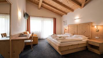Un dormitorio con estructura de madera, que incluye cama, escritorio, silla y mesita de noche.