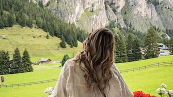 Una persona de pie en un balcón, con vistas a un paisaje montañoso.