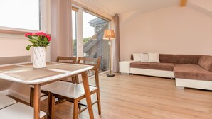 A modern living room with a dining table, chairs, a sofa, and a lamp. - Seaside apartments - Near Palanga Beach (Palanga)