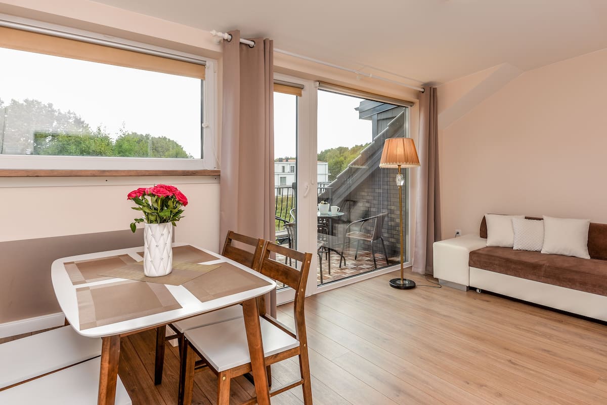 Een moderne woonkamer met een eettafel, stoelen, een bank en een vloerlamp.