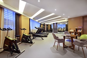 A gym with stationary bikes, treadmills, and a table with chairs. - Atour S Hotel Tai Koo Li Chengdu (Chengdu)