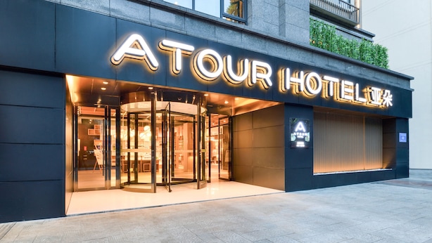 A hotel entrance with a revolving door and illuminated signage. - Atour Hotel Hongpailou Chengdu (Chengdu)