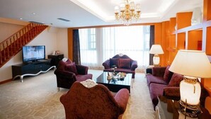 Ein modernes Wohnzimmer mit einer Sofagarnitur, einem Couchtisch und einem Fernseher.