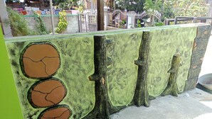 A bar with a unique tree bark design, a tiled floor, and a metal railing. - Gandrung City Hostel (Banyuwangi)