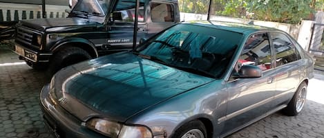 Un coche estacionado en un área de aparcamiento techada con suelo de baldosas.