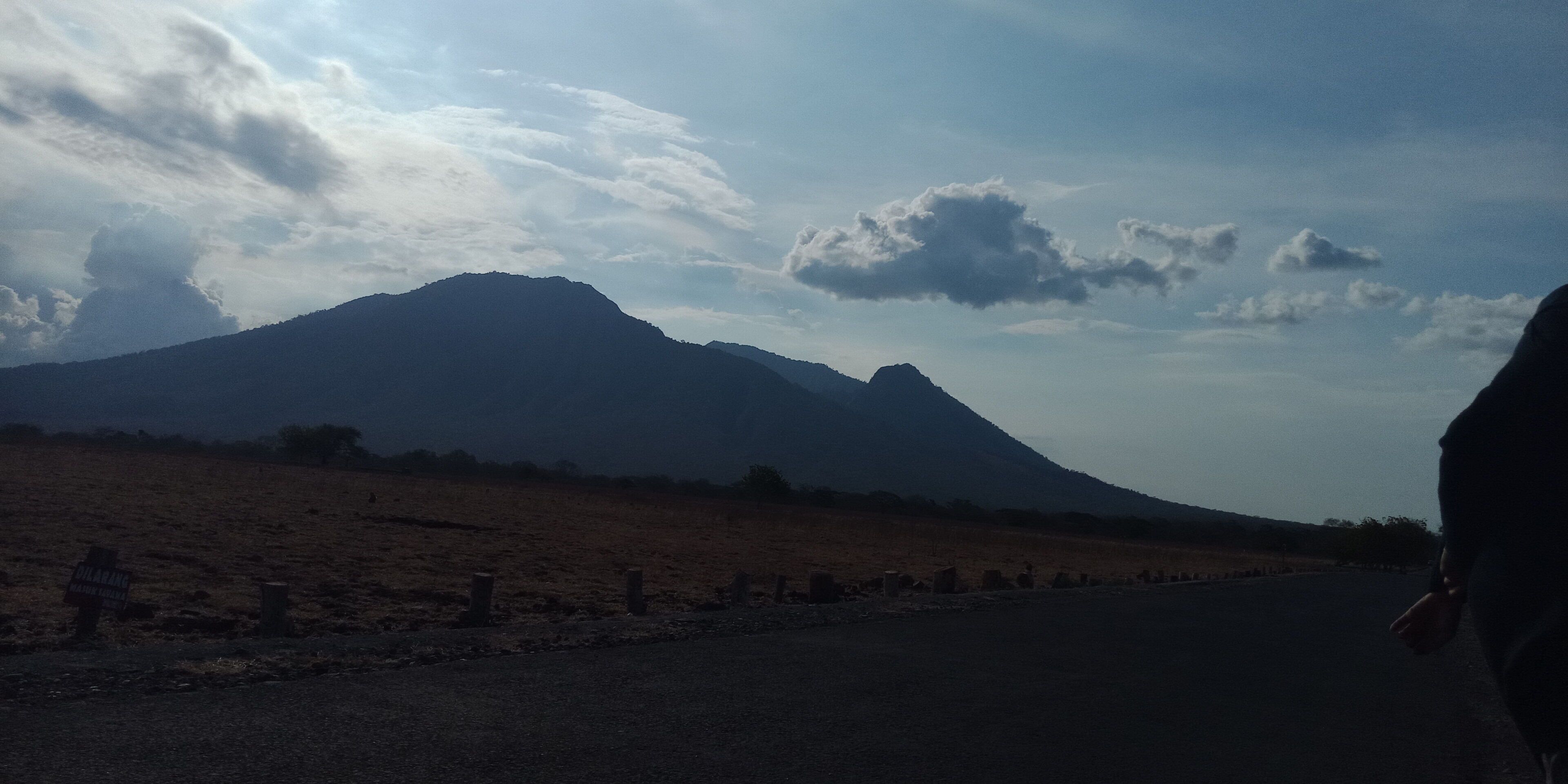 A road leading to a mountain with a sign indicating a viewpoint.