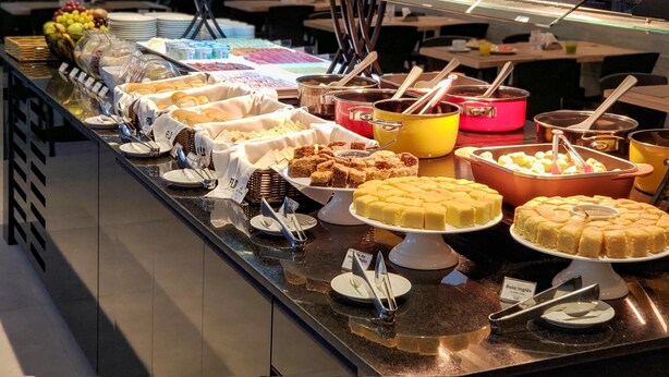 A buffet with various food items and utensils. - Flix Hotel (Maceió)