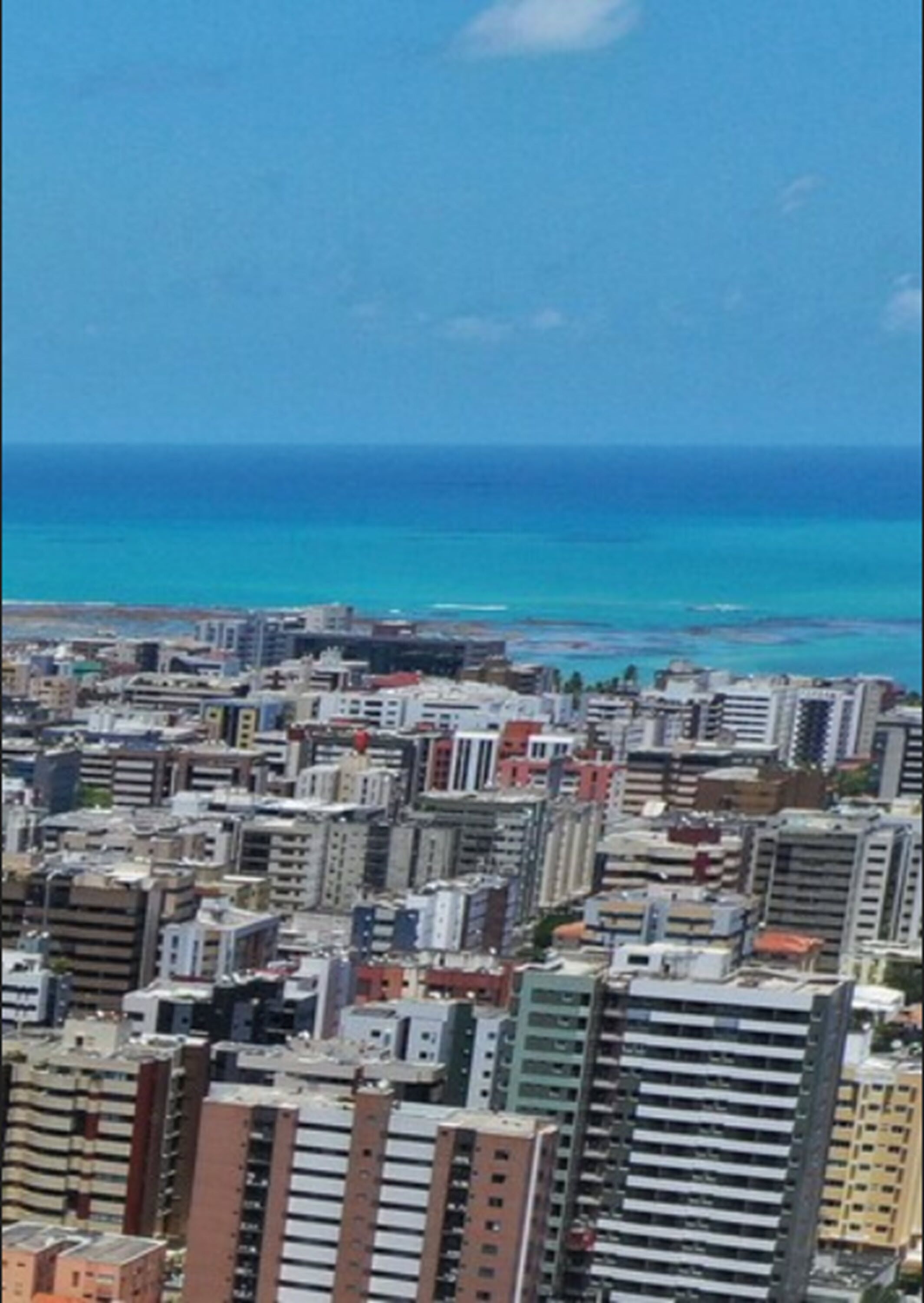 A cityscape with high-rise buildings and a view of the ocean.