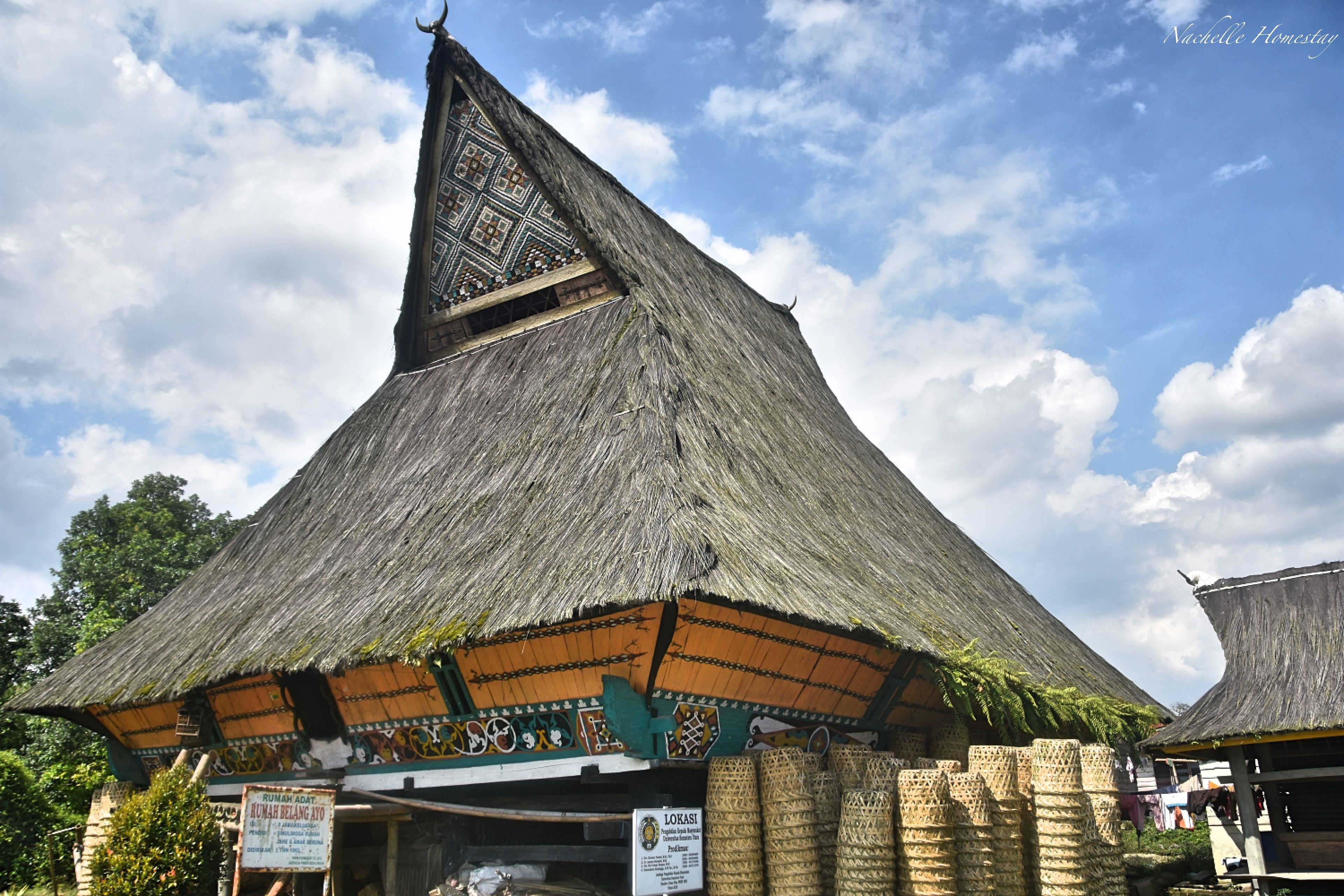 A traditional thatched-roof building with a steeply pitched roof and a decorative triangular section.