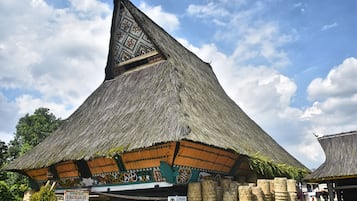 A traditional thatched-roof building with a steeply pitched roof and a decorative triangular section.