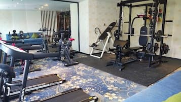 A home gym with treadmills, a weight bench, and a squat rack.