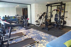A home gym with treadmills, a weight bench, and a squat rack. - Haoyi Hotel (Zhuzhou)