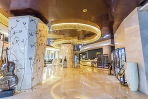 A spacious lobby with a curved ceiling and a central column with floral patterns. - Haoyi Hotel (Zhuzhou)